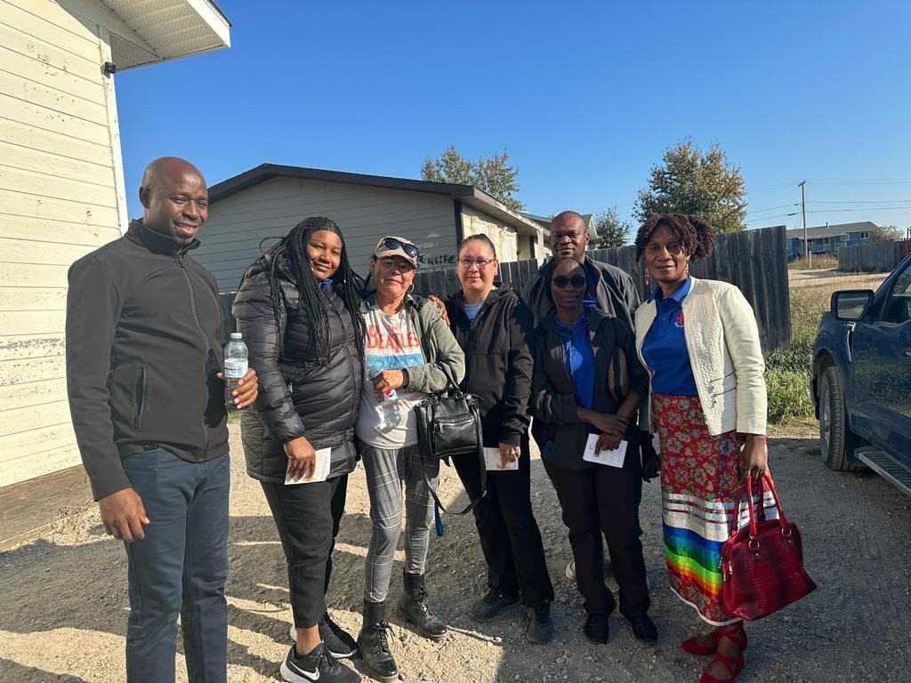 An outreach group standing together outside a home