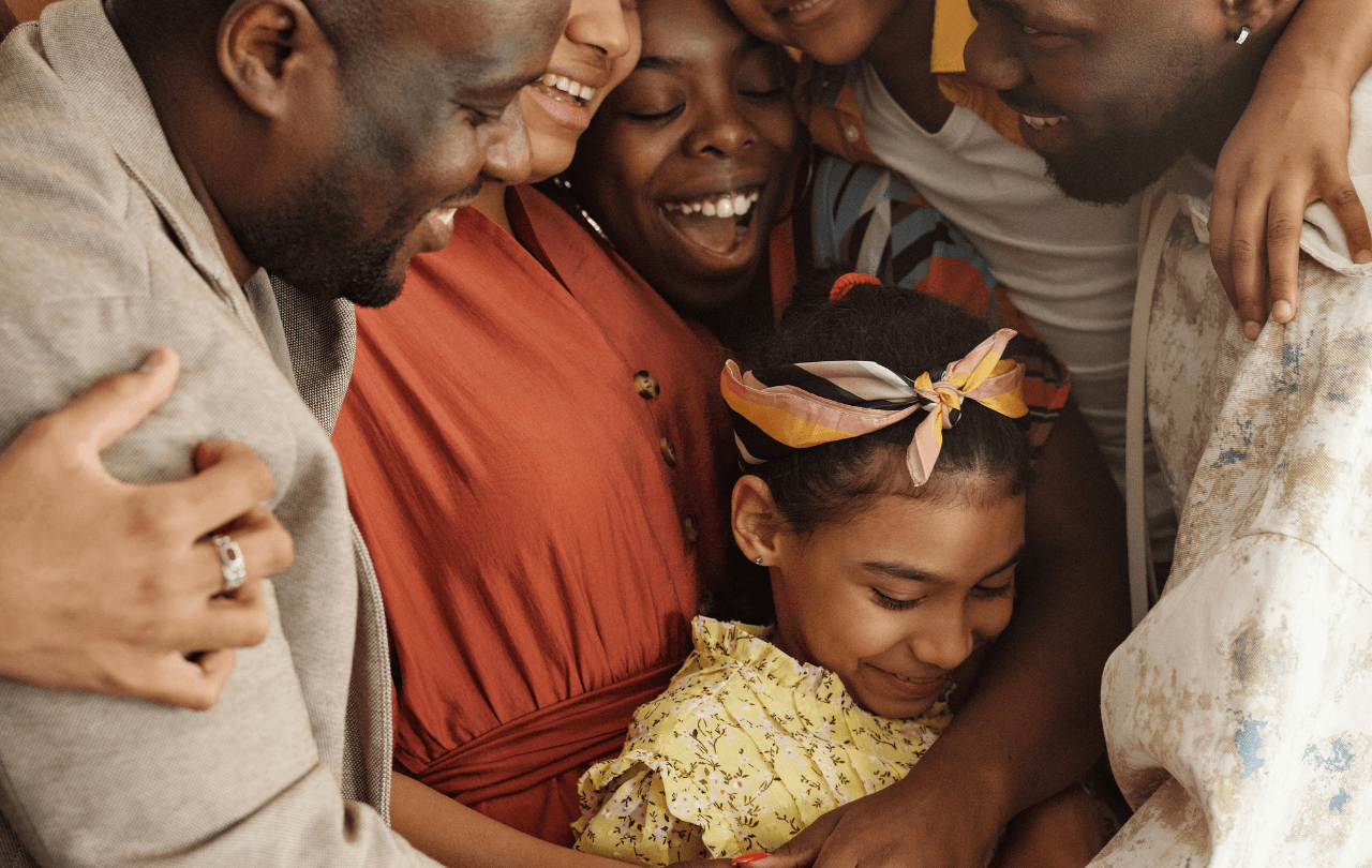 Adults and children sharing a joyful group embrace